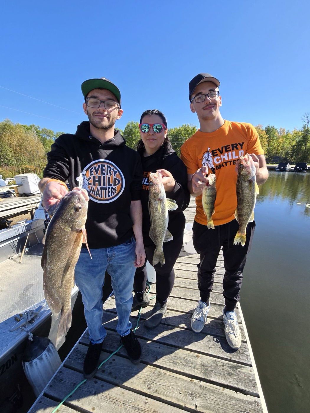 Group of guests on the dock holding walleye after a guided fishing charter on Lake Nipissing